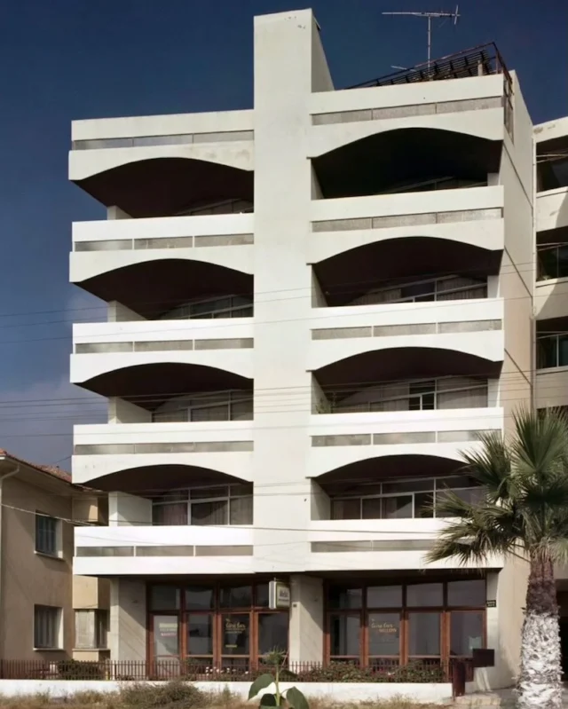 Sahil Apartmanı, Kuşadası – 1976TR | Kuşadası’nın kıyıdaki ilk modernist apartman örneklerinden biri olan Sahil Apartmanı, dönemin kartpostallarında da yer alarak kentin görsel belleğinde iz bırakmıştır. Tekne karinasından esinlenen kıvrımlı balkonları, sonraki yıllarda başka mimarlar tarafından da benimsenerek Kuşadası’nın kıyı mimarlığında yaygınlaşacaktır. Yapı arsa sınırlarını izlerken, balkonların denize paralel bir hatta sonlanması cepheye dinamizm kazandırır ve konutlardan deniz manzarasına geniş bir görüş açısı sağlar. Özgün cephe çizimlerinin yanı sıra iç mekân ve balkon yaşantısını betimleyen el çizimi eskizlerde, Nafi Çil’in 1970’lerin Kuşadası için öngördüğü denizle iç içe yaşamı da izlemek mümkündür.Sahil Apartment Building, Kuşadası – 1976EN | One of the earliest modernist apartment buildings along the Kuşadası waterfront, Sahil Apartment Building also appeared on postcards of the period, leaving its mark on the town’s visual memory. Its curved balconies, inspired by the hull of a boat, would later be adopted by other architects and become a recurring feature of Kuşadası’s coastal architecture. While the building follows the boundaries of its plot, the balconies terminate along a line parallel to the sea, lending dynamism to the façade and providing residents with expansive views of the sea. Alongside the original elevation drawings, hand-drawn sketches depicting interior spaces and life on the balconies offer a glimpse into the close relationship with the sea that Nafi Çil envisioned for life in Kuşadası in the 1970s.#naficil #SahilApartmani #Kuşadasi #AegeanArchitecture #ArchitecturalArchive